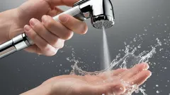 Lavaggio delle mani con doccetta bidet cromata e spruzzo d’acqua, igiene personale.