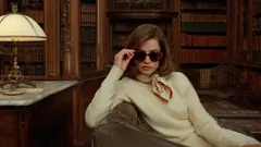 Donna elegante con occhiali da sole in biblioteca, atmosfera sofisticata e retrò.
