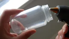 Attacco di colla a caldo su barattolo di plastica trasparente per fai da te.